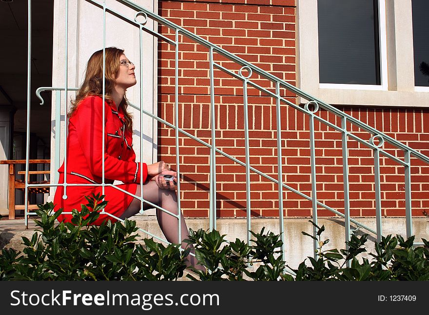 Businesswoman sitting on stairs with cell phone. Businesswoman sitting on stairs with cell phone