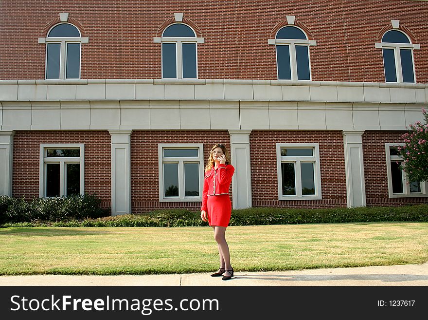 Businesswoman on cell phone; brick building background. Businesswoman on cell phone; brick building background