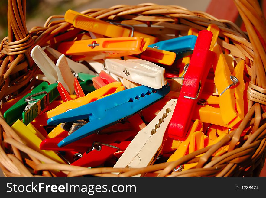 Colorful cloth pegs in a basket