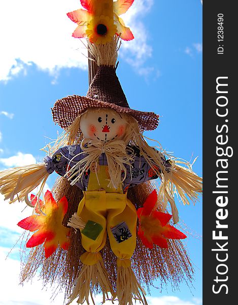 Little cute scarecrow with sky as background