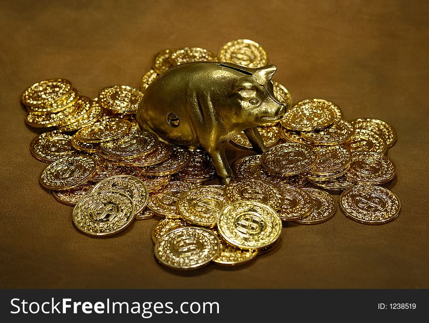 Photo of Gold Coins and a Brass Piggy Bank. Photo of Gold Coins and a Brass Piggy Bank