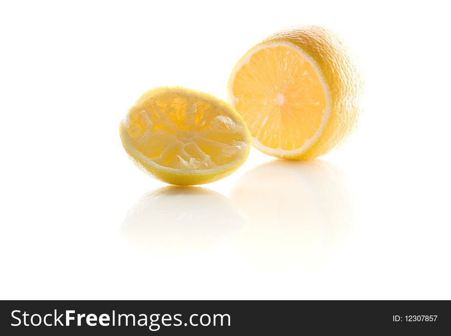 Squeezed lemon lie on the white reflecting white surface
