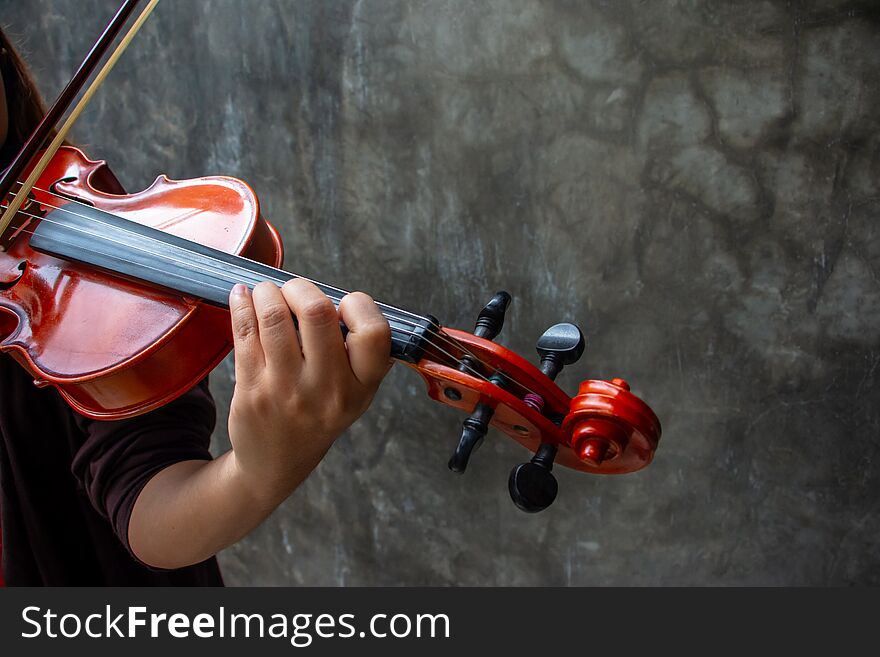 Closeup photo of Violinist playing the violin. The classical musician photo with dark background.