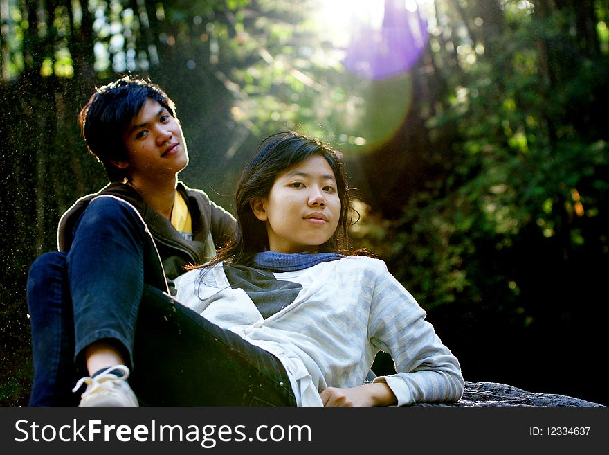 A couple relaxes on the rocks as the sun shines in the sky. A couple relaxes on the rocks as the sun shines in the sky.