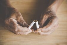 No Smoking Day Concept With Old Male Hand Crushing Cigarette Stock Images
