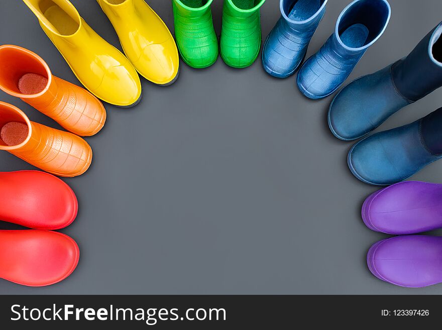 Colorful rubber boots-red, orange, yellow, green, cyan, blue and purple stand in the shape of a rainbow .