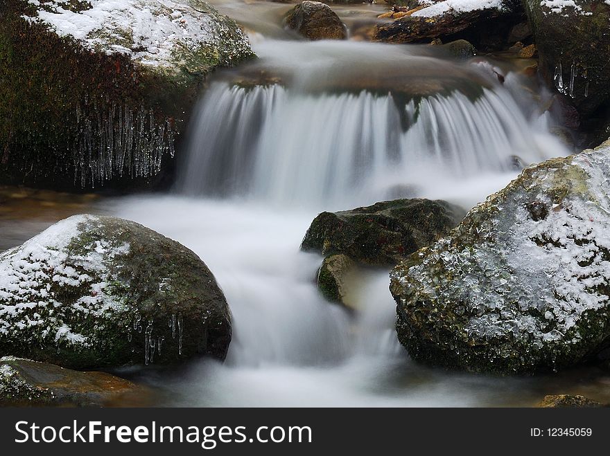 Soft waterfall on icy rocks