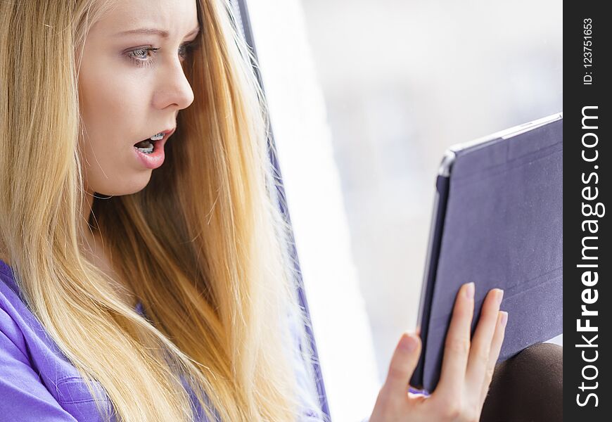 Shocked girl watching on tablet