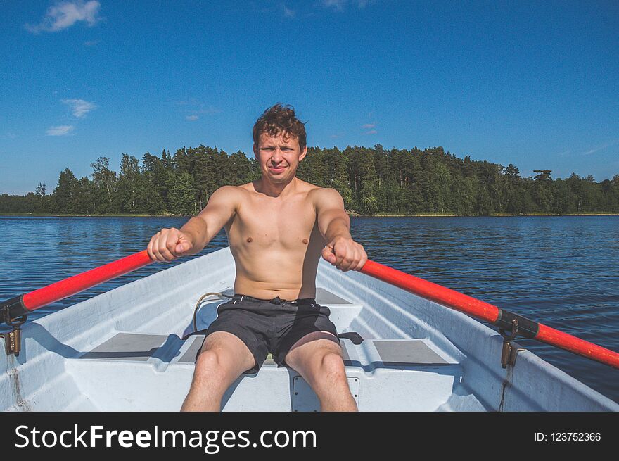 The Man In A Boat Rowing On The Lake