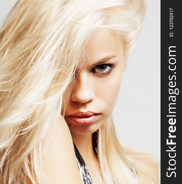 Young pretty woman with blond hair on white background, sensual makeup, fashion look, lifestyle people concept close up