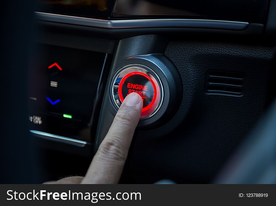 Fingers pressing car start button
