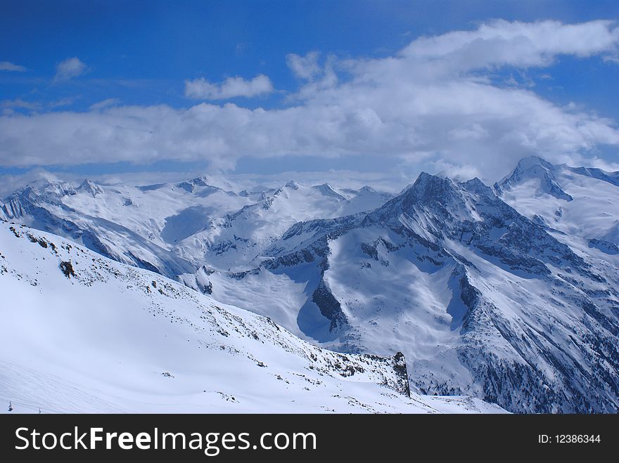 A beautiful landscape, from the top of the Hinter-tux glacier in Mayrhofen, Austria, Alps, at the height of 3250 metres. White sunny mountain slopes and blue sky. A beautiful landscape, from the top of the Hinter-tux glacier in Mayrhofen, Austria, Alps, at the height of 3250 metres. White sunny mountain slopes and blue sky