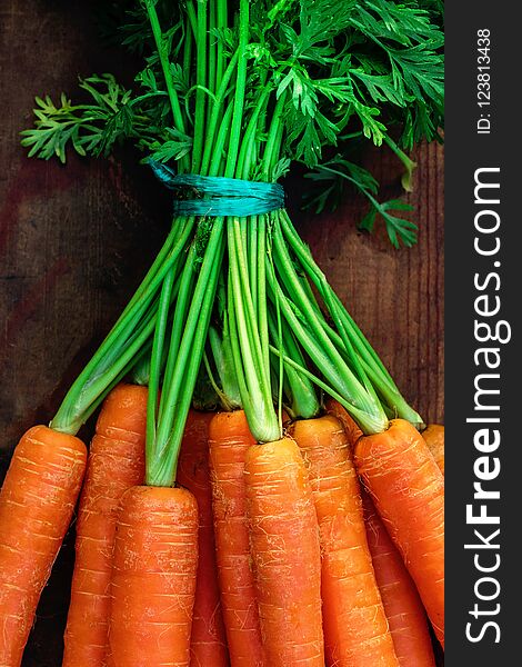 Fresh carrots bunch on rustic wooden background with copy space. Healthy Detox concept