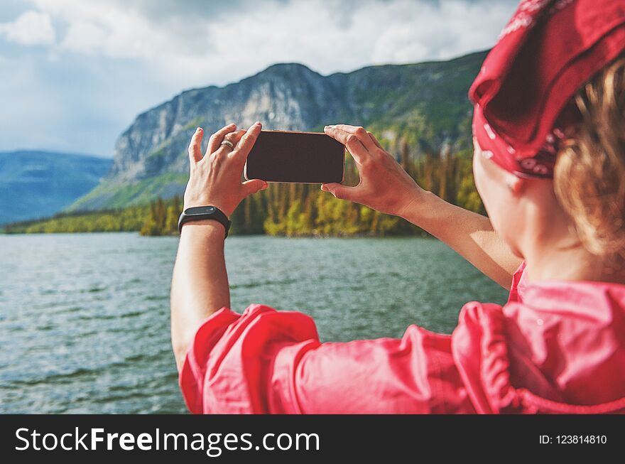 Tourist woman taking photo of lake and mountain. Tourism concept