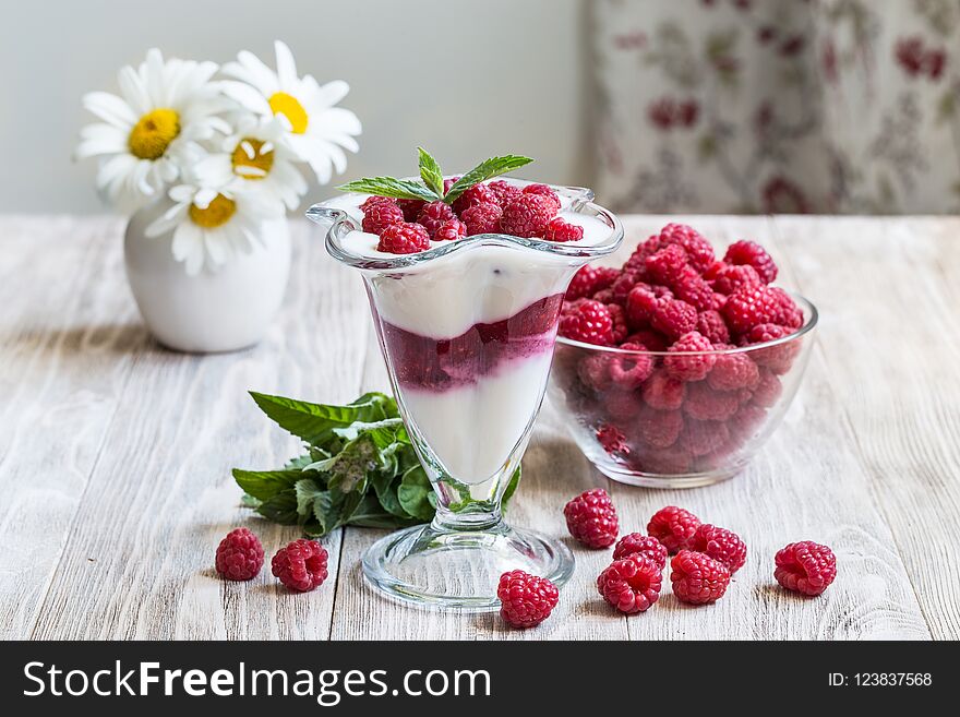 Yogurt with raspberries and mint on a wooden background. Yogurt with raspberries and mint on a wooden background.