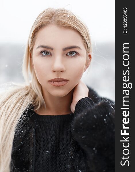 Portrait of a beautiful young blonde in a black jacket. Winter day. Portrait of a beautiful young blonde in a black jacket. Winter day