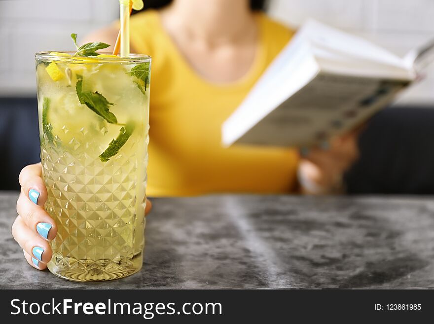 Woman with glass of lemonade at table