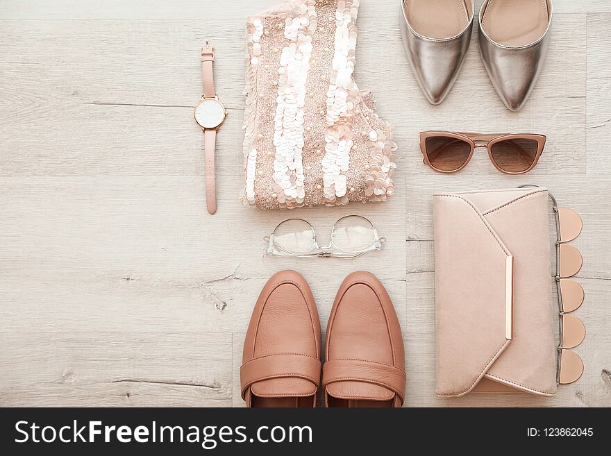 Flat lay composition with stylish female outfit and space for text on wooden background