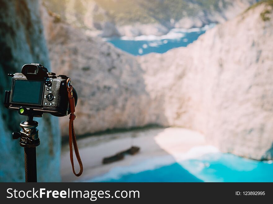 Digital camera on tripod capture photo of Shipwreck in Navagio beach in morning sun light. Famous visiting landmark