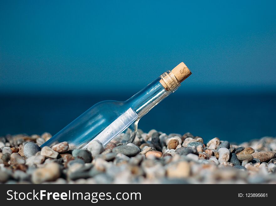 Rolled letter inside glass bottle on a beach. Rolled letter inside glass bottle on a beach