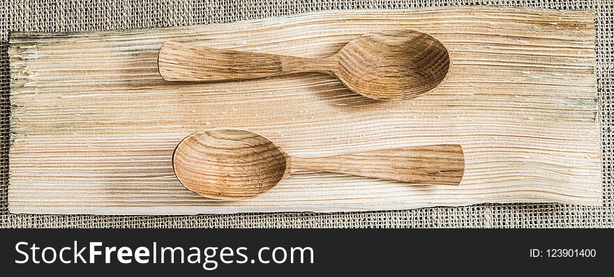 Two wooden spoons on a wooden texture board made from wooden logs. Two wooden spoons on a wooden texture board made from wooden logs