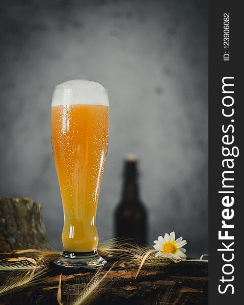 German cold beer on wooden logs with different textures and background in large elongated glass. German cold beer on wooden logs with different textures and background in large elongated glass