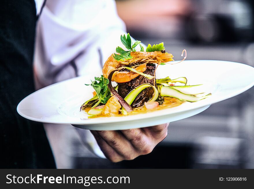 Modern food stylist decorating meal for presentation in restaurant. Closeup of food stylish. Restaurant serving