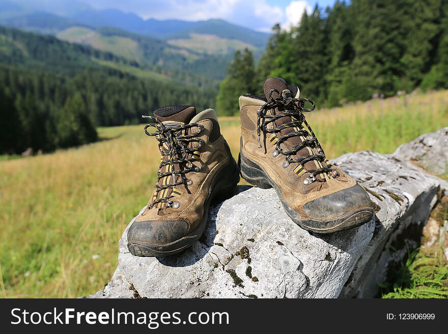 Hikers boots on stone on mountain meadow