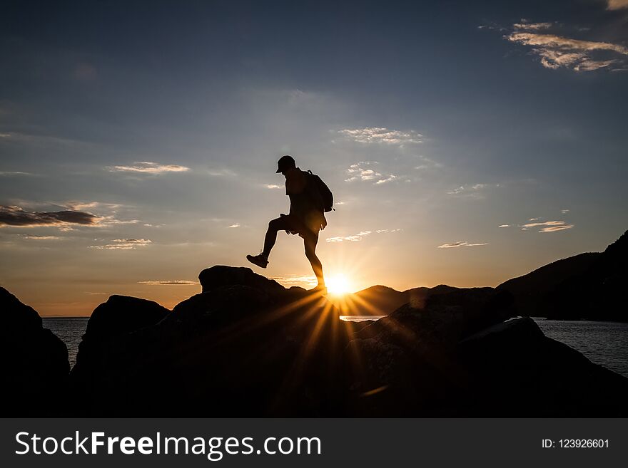 Silhouette of a traveler hiking on mountain at sunset.Freedom, risk, challenge, success concept. Silhouette of a traveler hiking on mountain at sunset.Freedom, risk, challenge, success concept.