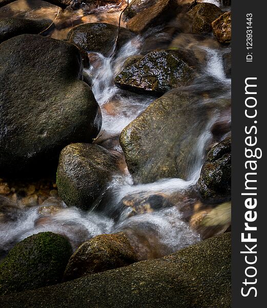 Mountain Stream Creek Waterfall Flowing Through Rocks In A Tropical Forest.