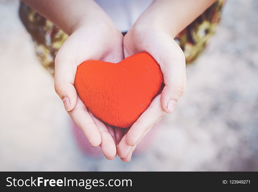 Small kid hands holding heart.