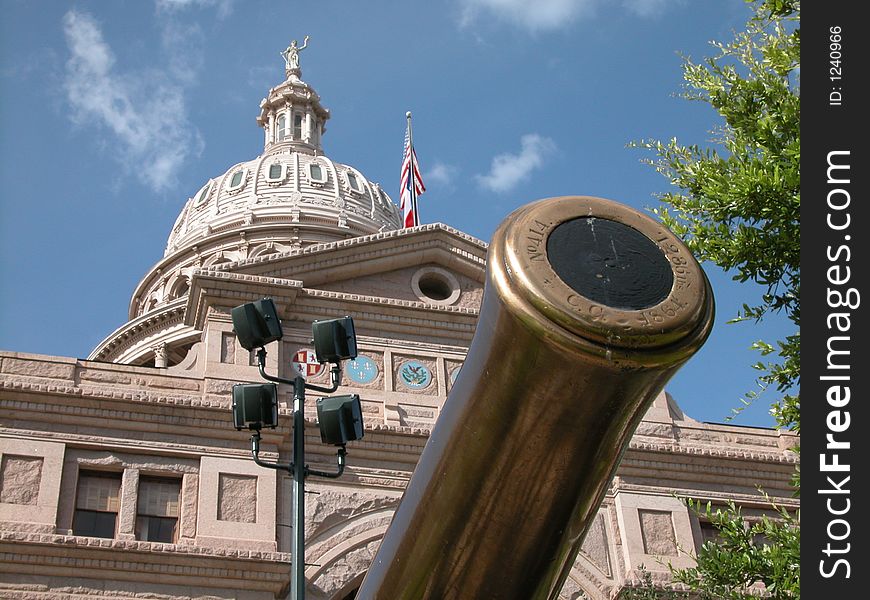State of Texas Capitol building entrance with a restored cannon seemingly defending the historic building. State of Texas Capitol building entrance with a restored cannon seemingly defending the historic building.