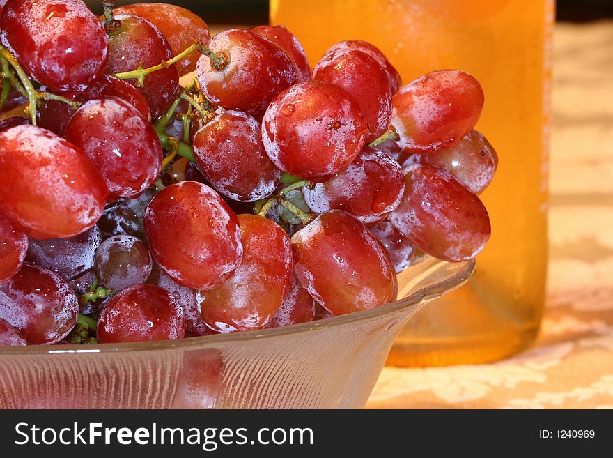 Close up of a cluster of grapes and a wine bottle. Close up of a cluster of grapes and a wine bottle