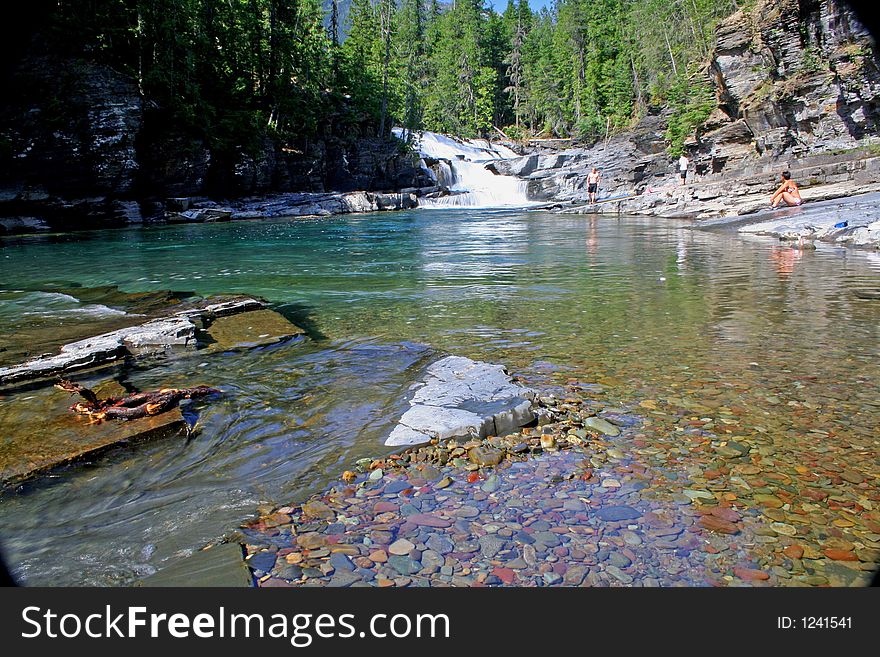 Sunbathers and swimmer enjoy MacDonald Falls and Creek. Sunbathers and swimmer enjoy MacDonald Falls and Creek