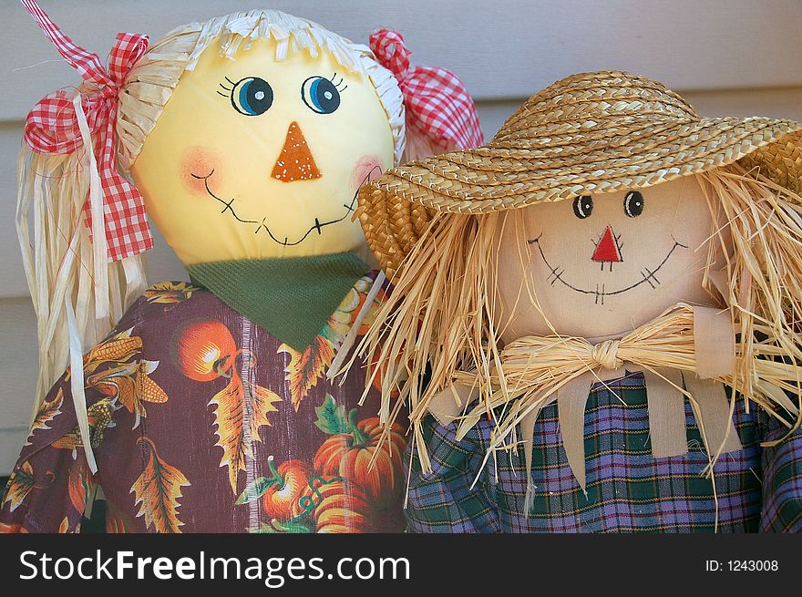 Boy and girl scarecrow with red bows and straw hat. Boy and girl scarecrow with red bows and straw hat.