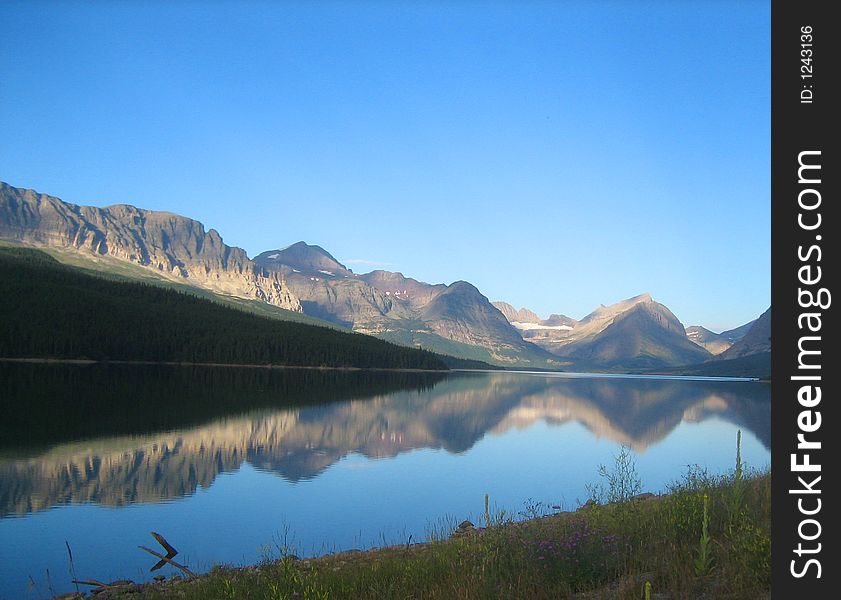 An early morning mountain range perfectly reflected in the water below. An early morning mountain range perfectly reflected in the water below