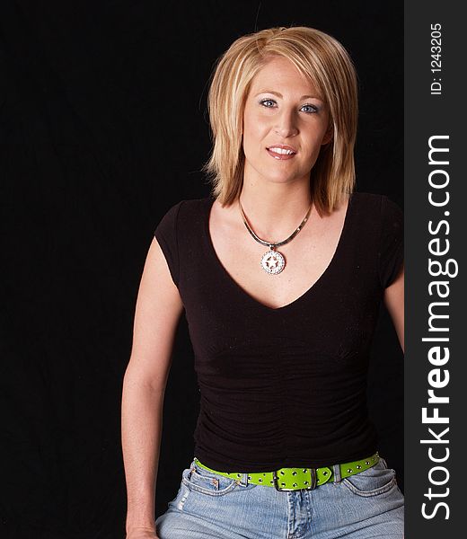 Young blond model posing on black with a black shirt on. Young blond model posing on black with a black shirt on
