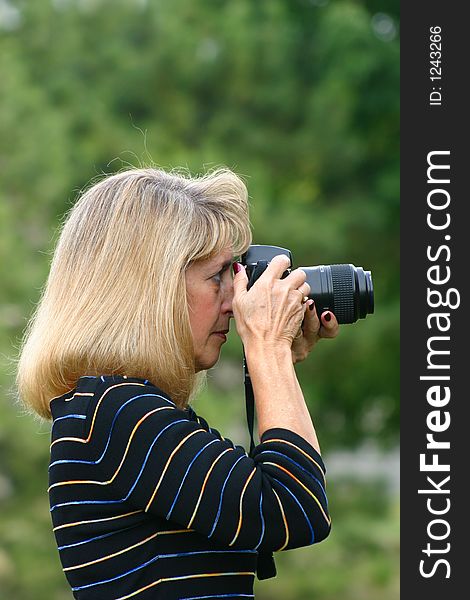 Woman taking a picture outdoors. Woman taking a picture outdoors