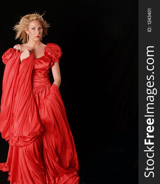 Young attractive model wrapped in red on a black background. Young attractive model wrapped in red on a black background