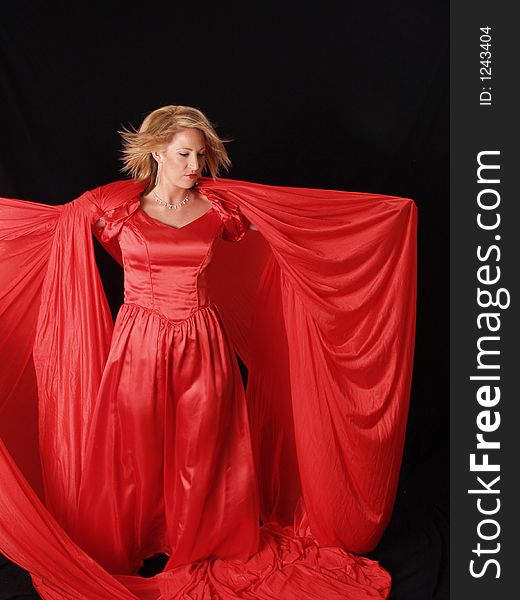 Young attractive model wrapped in red on a black background. Young attractive model wrapped in red on a black background