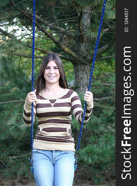 Girl outdoors smiling sitting on swing