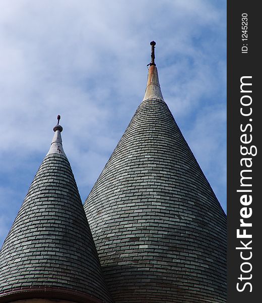 Two conical tiled pointed rooftops on castle towers close up. Two conical tiled pointed rooftops on castle towers close up