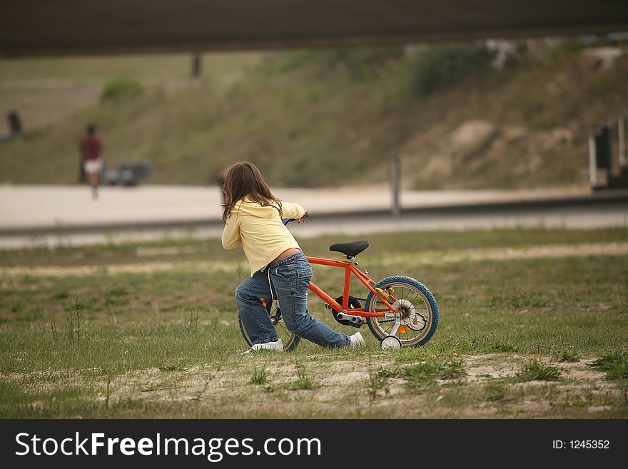 Girl push a bicycle in the park