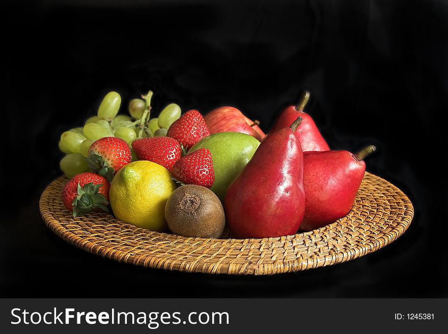 Colorful arrangement of fruit on a plate with black background. Colorful arrangement of fruit on a plate with black background