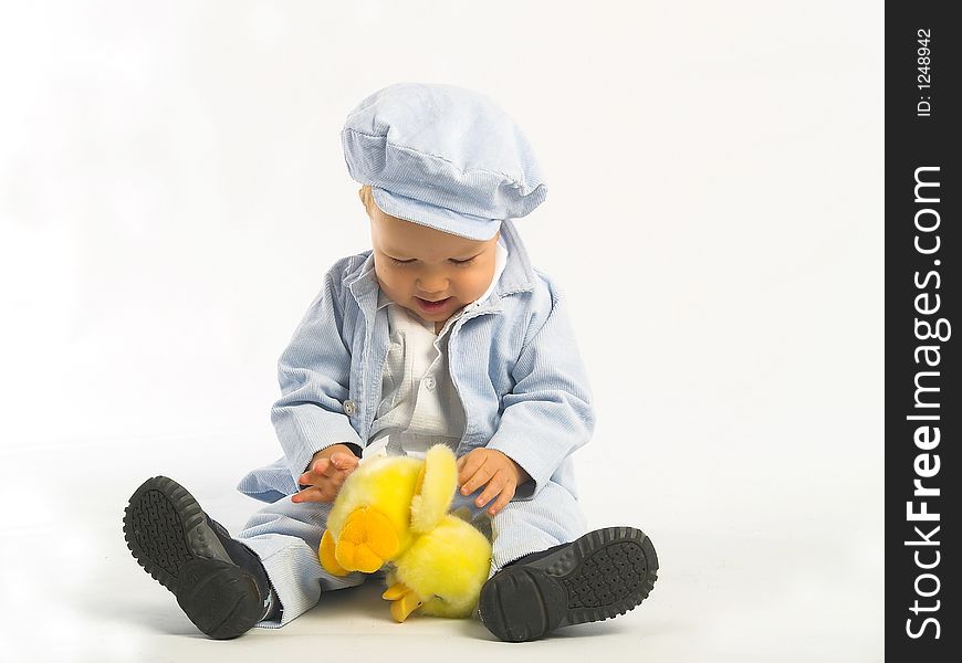 Little boy with yellow toy. Photo in studio. White background
