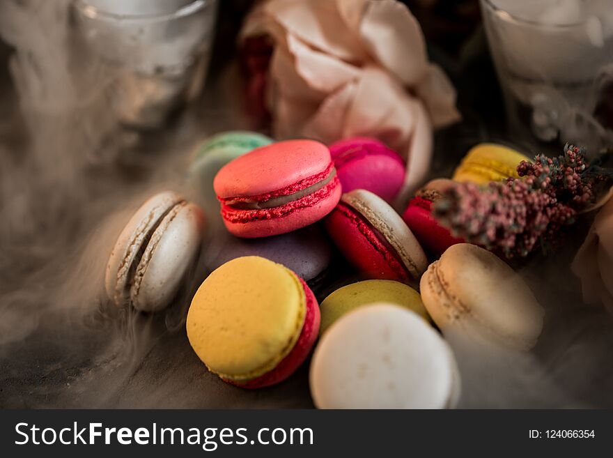 Cake macaroon in fog background. Close up macaron dessert on top of hill. Colorful almond cookies in pastel pink, yellow colors. Vintage toning style.