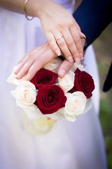 Wedding Bouquet Of Red Roses In The Hands Of The Bride And Groom Stock Photos