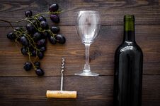 Composition With Wine. Red Wine Bottle, Bunch Of Grapes, Corkscrew, Wine Glass On Dark Wooden Background Top View Royalty Free Stock Images