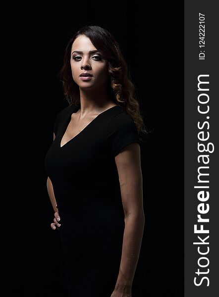 A portrait of a beautiful confident woman standing over black background. A portrait of a beautiful confident woman standing over black background