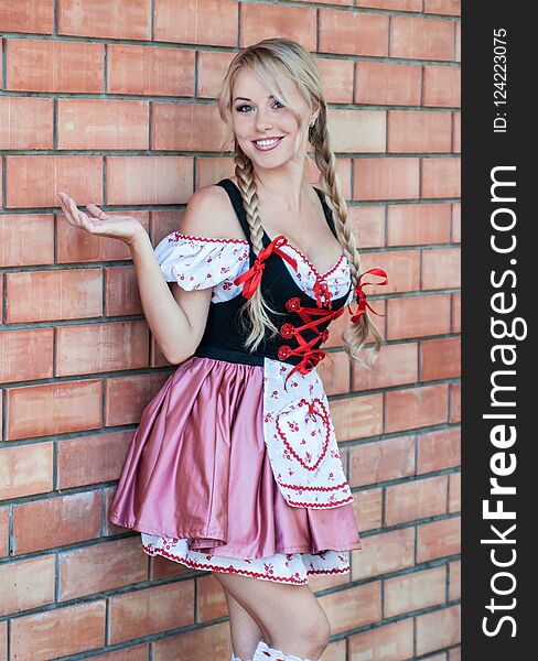Beautiful young woman on stone background in Octoberfest dress. Beautiful young woman on stone background in Octoberfest dress.